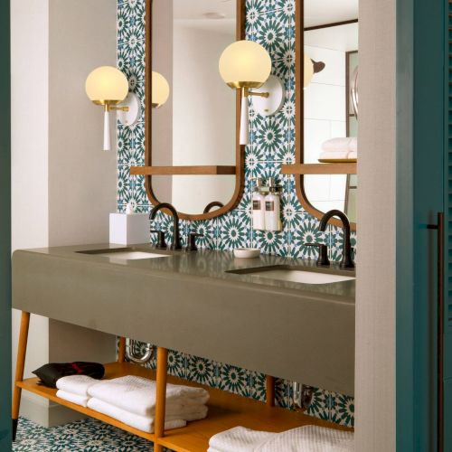 A cozy kitchen scene with a sink, wooden shelves, copper pots, and hanging mugs framed by green window shutters top it at 140 characters, always ending the sentence.